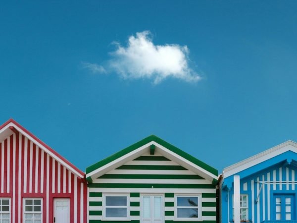 three assorted-color houses next to each other